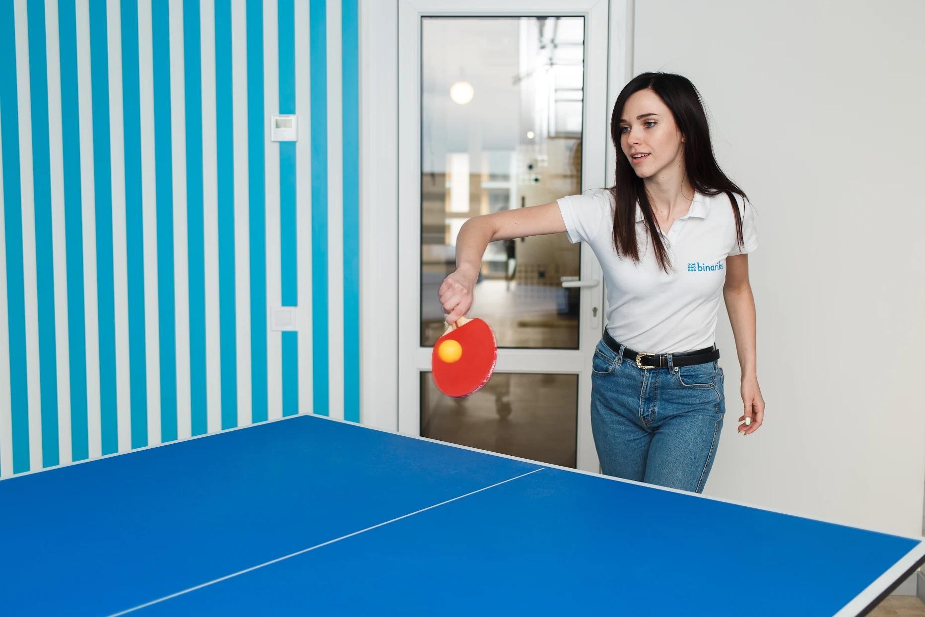 A Binariks colleague playing table tennis in the office