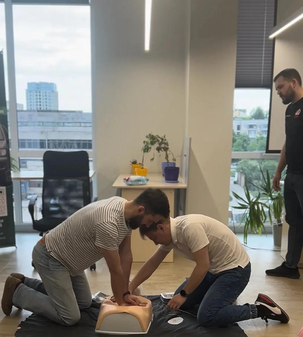 Binariks employees practicing CPR on a training mannequin